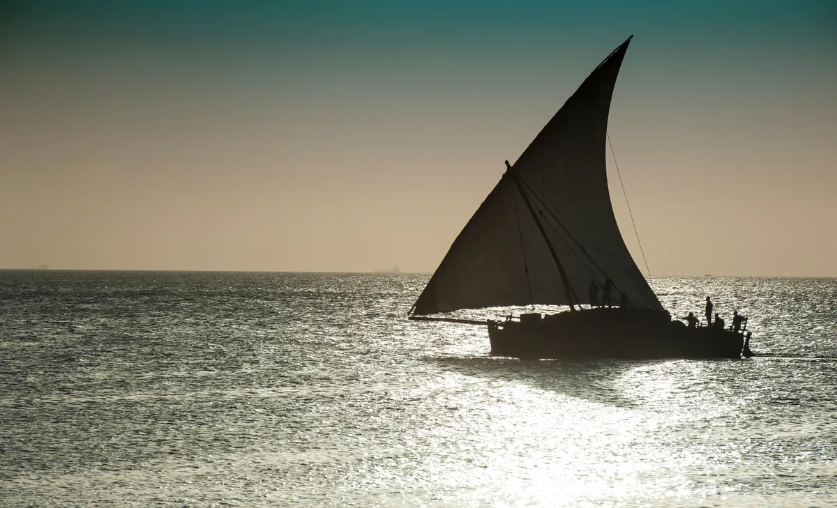 Dhow tradicional navegando al atardecer frente a Zanzíbar