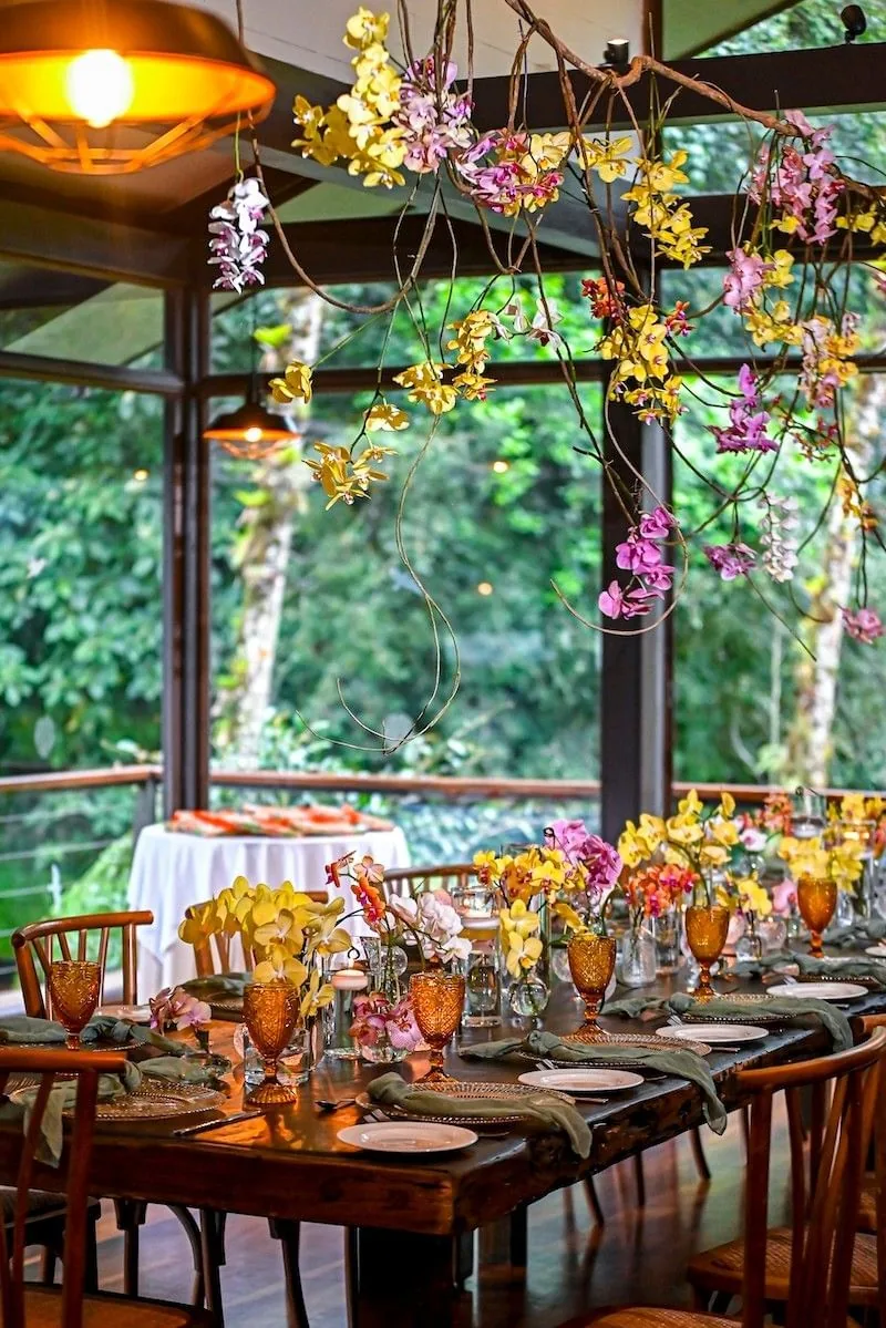 Mesa gastronómica entre orquídeas en un alojamiento de Costa Rica