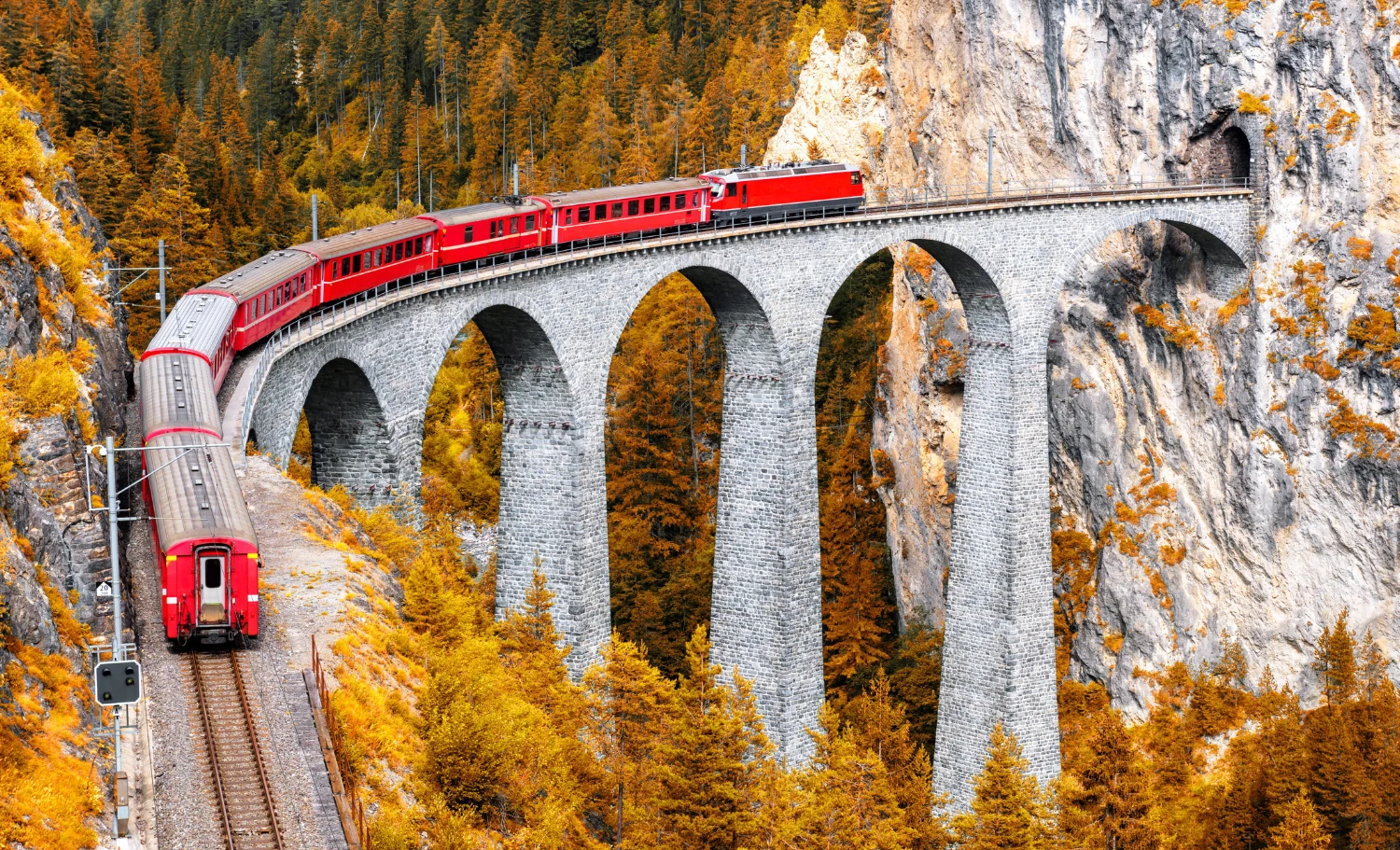 Tren panorámico atravesando un viaducto de montaña durante un viaje en familia